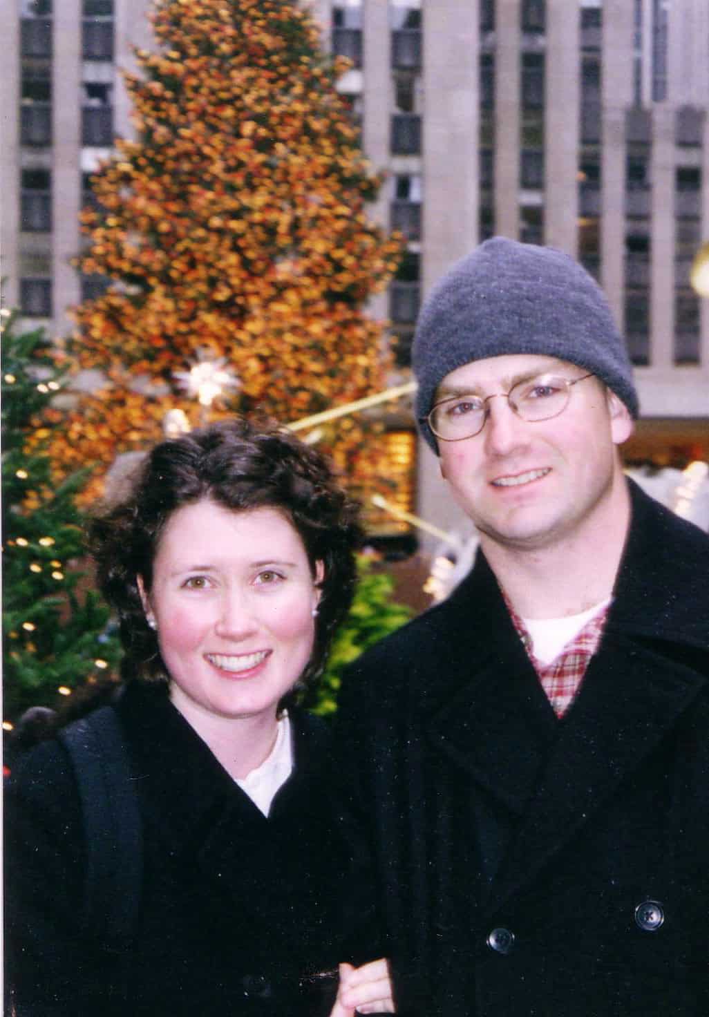 A young couple in front of the Rockefeller Center Christmas tree