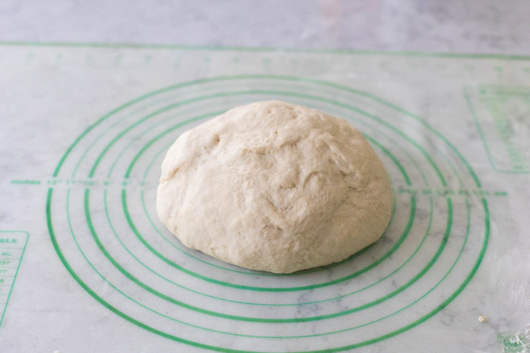 The dough has been kneaded and formed into a round ball.