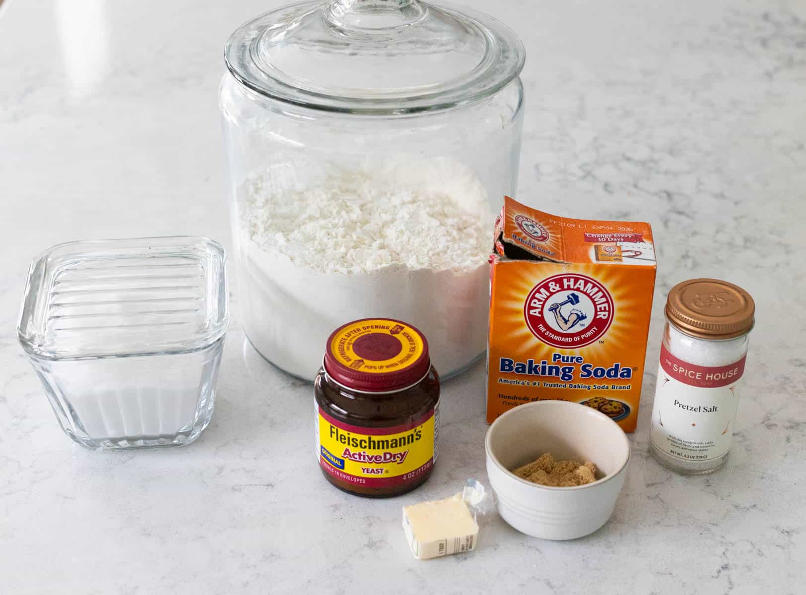 The ingredients to make homemade soft baked pretzels with kids are on the counter.