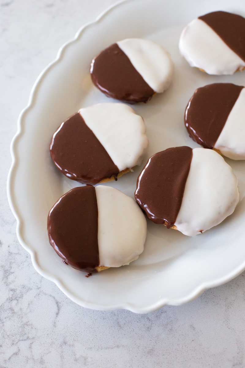 The finished NYC black and white cookies are served on a white platter.