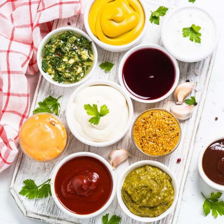 Several containers of different dipping sauces are laid out for shrimp.