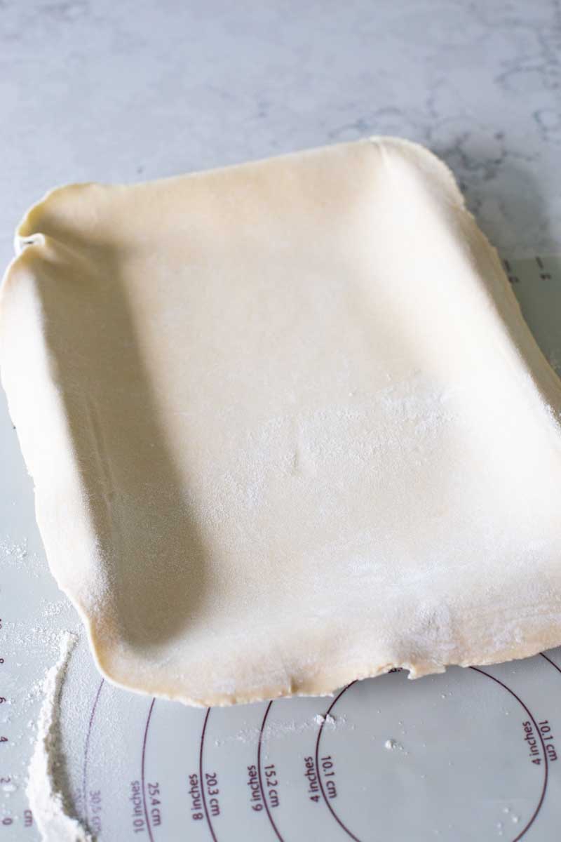 A pie crust has been draped over a pie pan.
