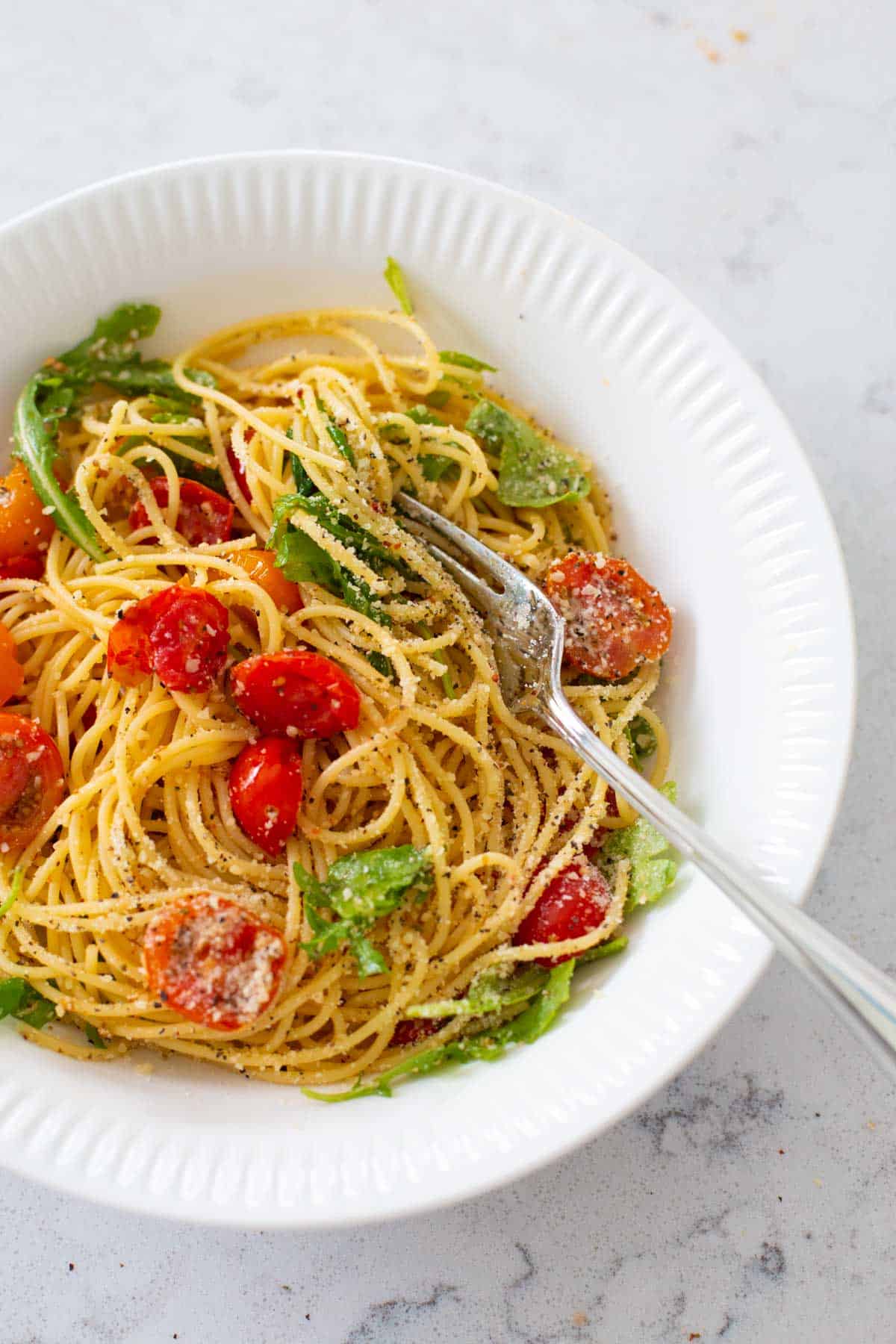 The bowl of pasta is ready to be eaten with the fork.