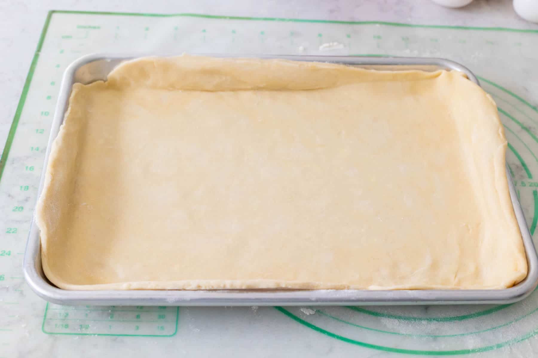 The bottom crust has been smoothed out into the baking pan.