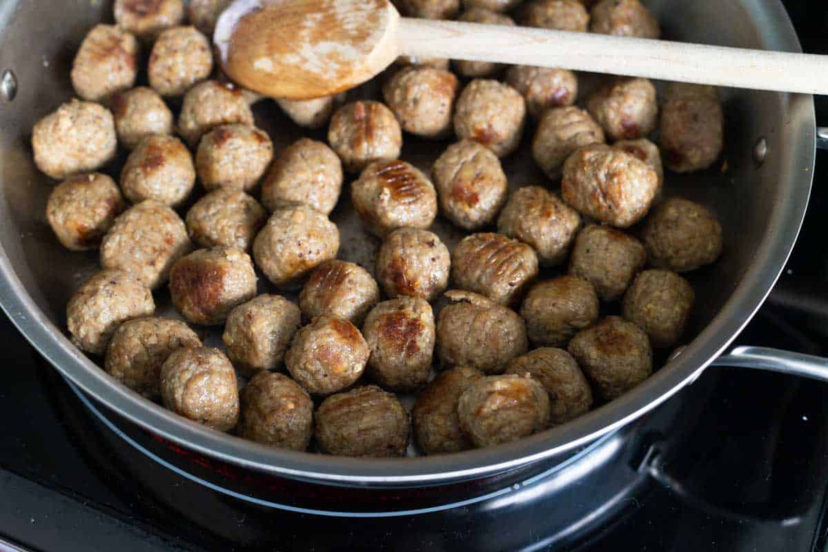 The frozen meatballs have been browned in a large skillet.