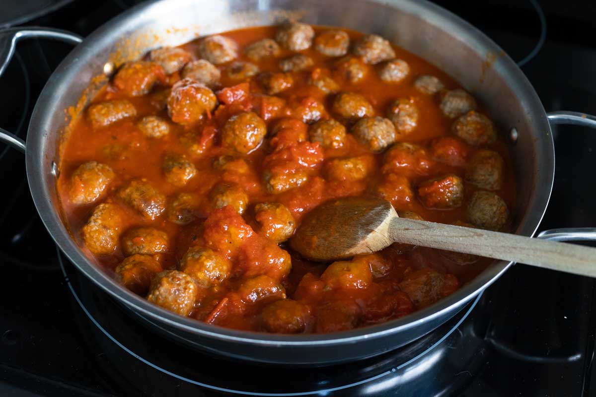 The tomato sauce has been poured over the meatballs.