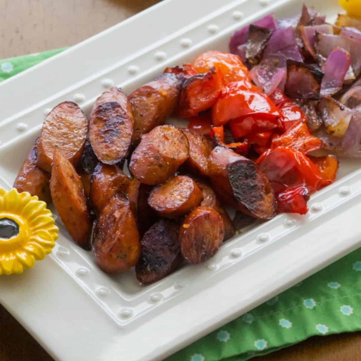 A platter of chopped sausages and red peppers are ready for tossing into pasta.