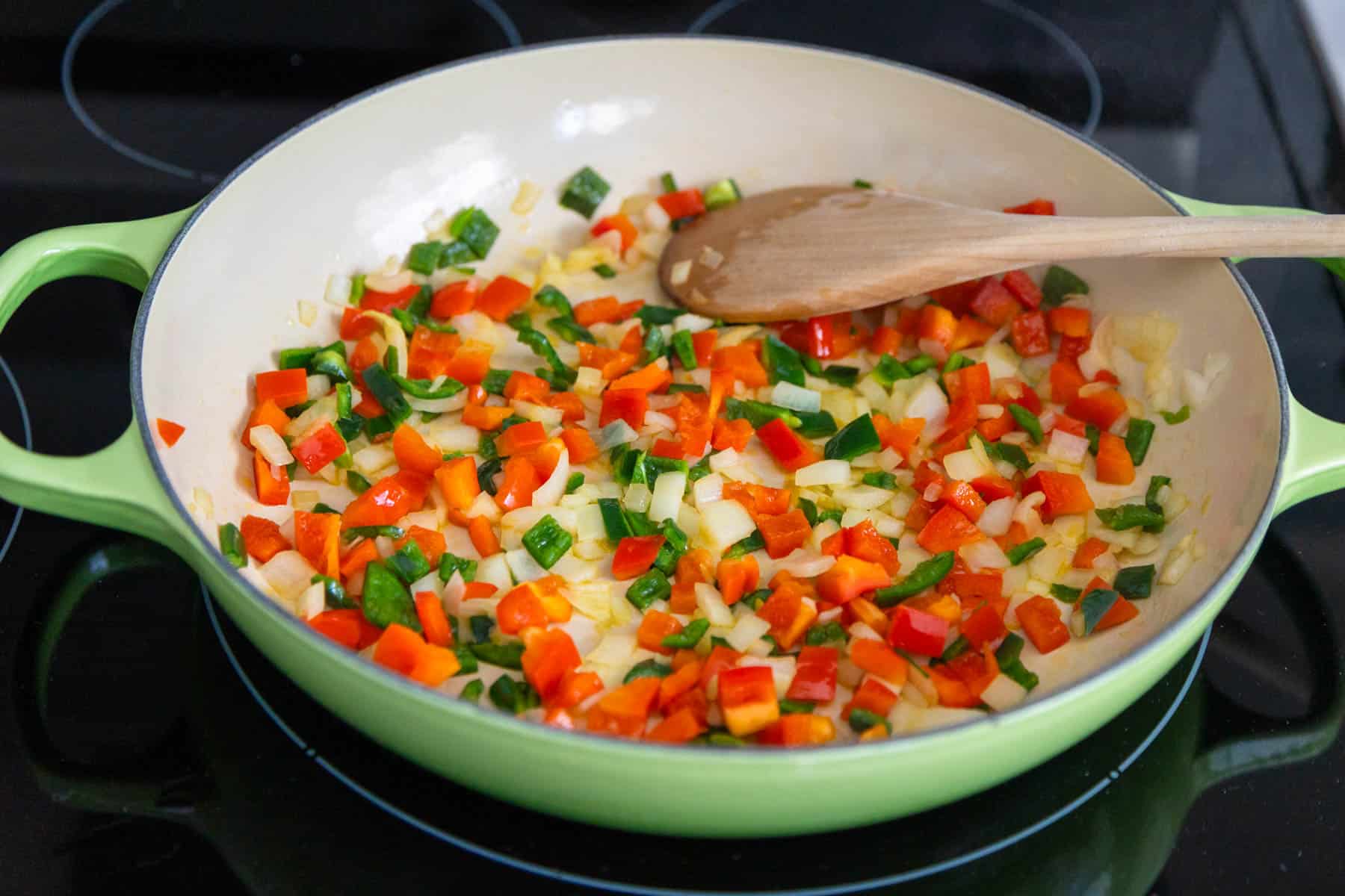 Saute the veggies in a large oven-proof skillet, stir them with a wooden spoon.