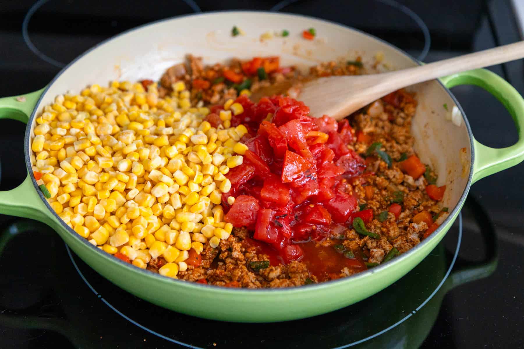 The tomatoes and corn have been added to the skillet.
