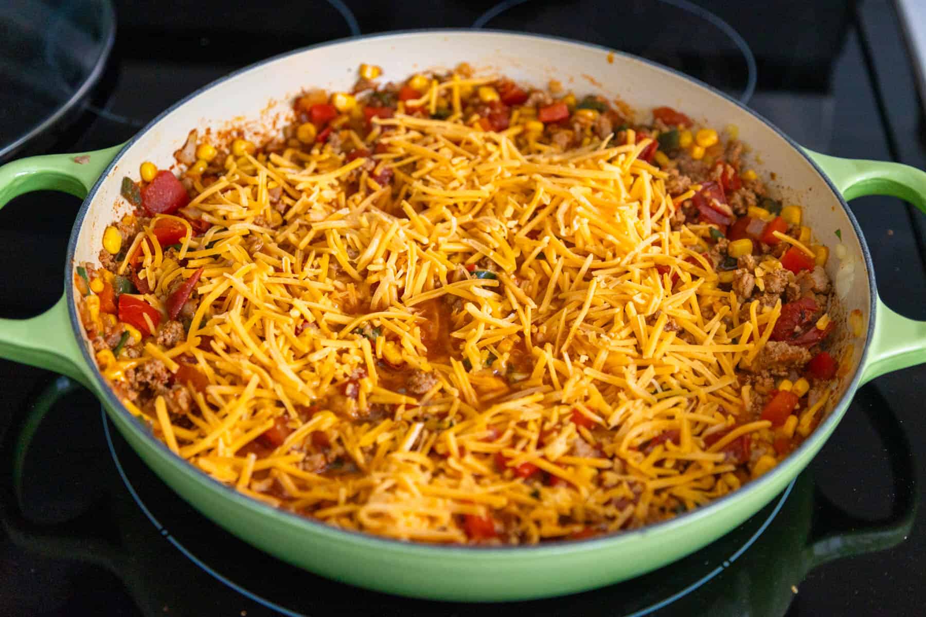 Shredded cheese has been sprinkled over the skillet.