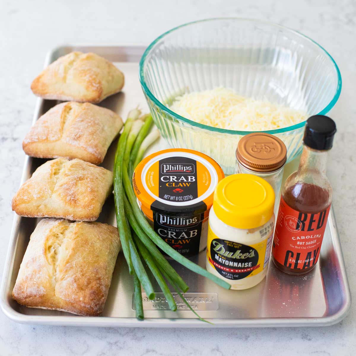 Easy ingredients for crab melts are on a metal baking tray.