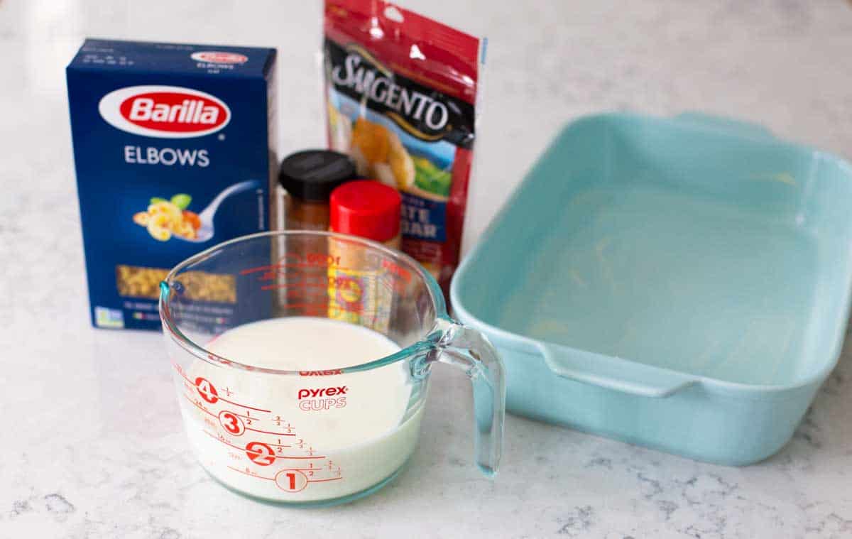 The ingredients to make baked mac and cheese are on the counter.