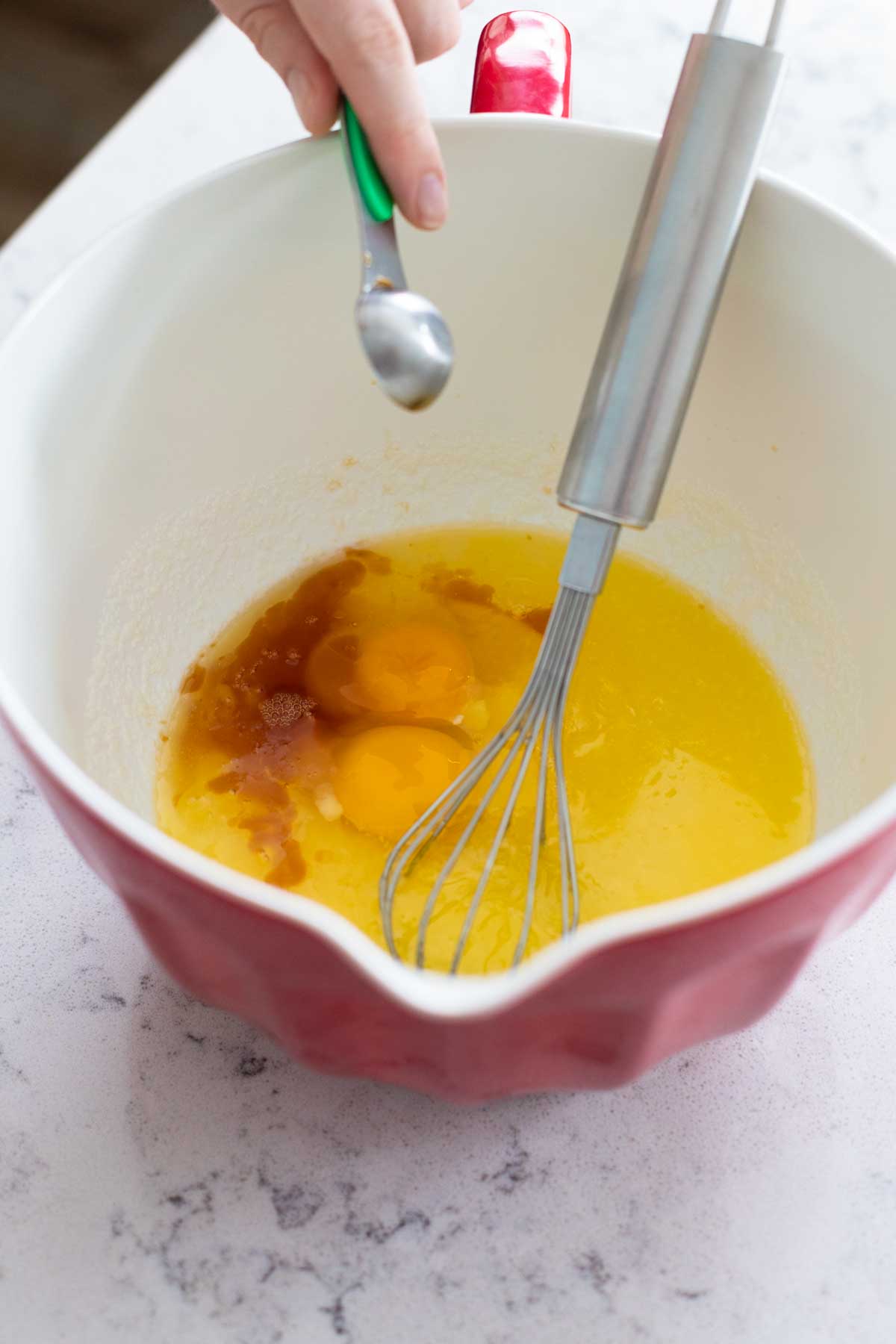The eggs and vanilla have been added to the batter bowl.