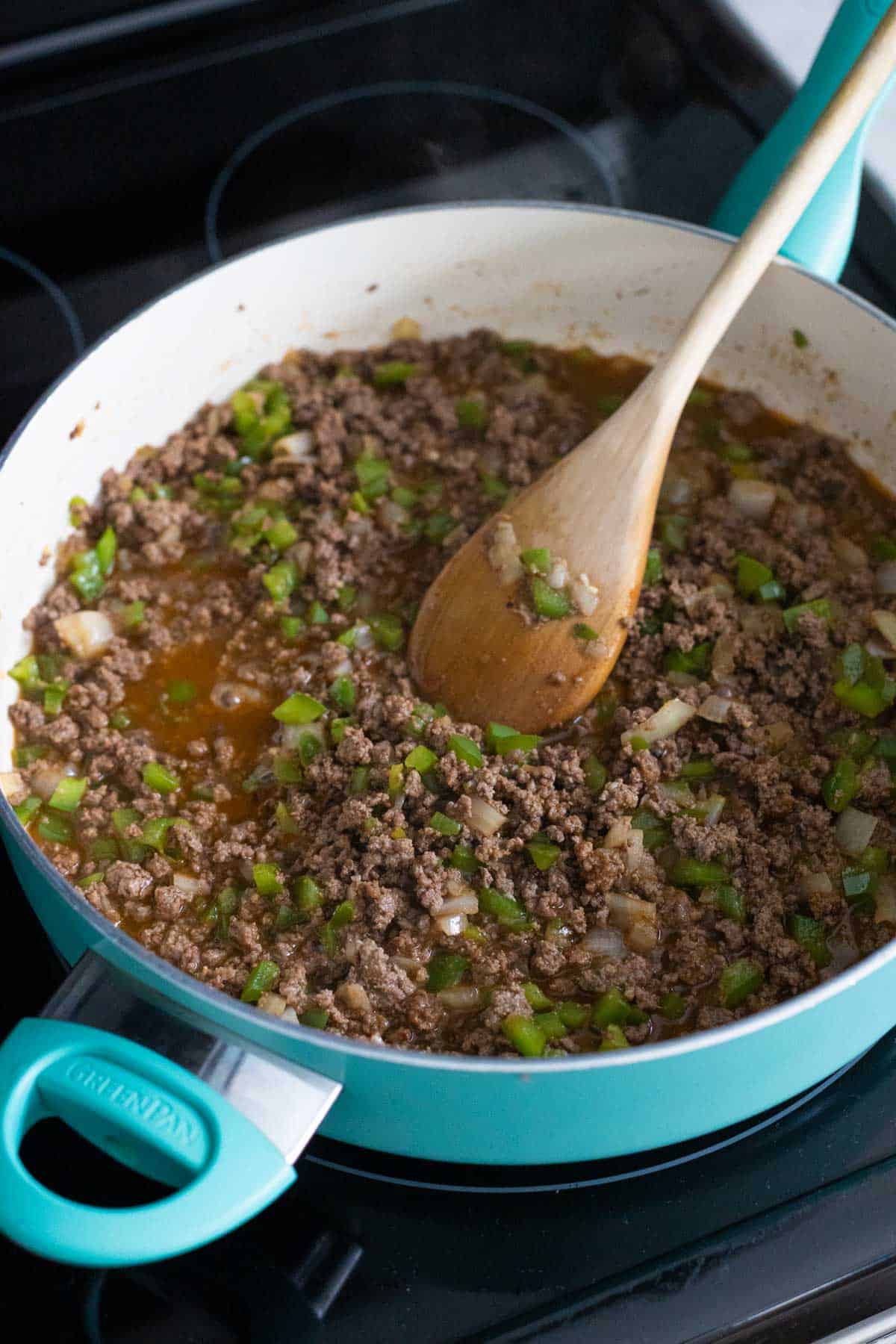 The skillet has the finished sloppy joe mix simmering to thicken the sauce.