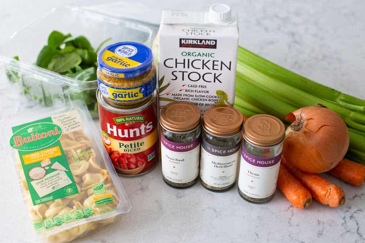 The ingredients to make tortellini soup are on the counter.