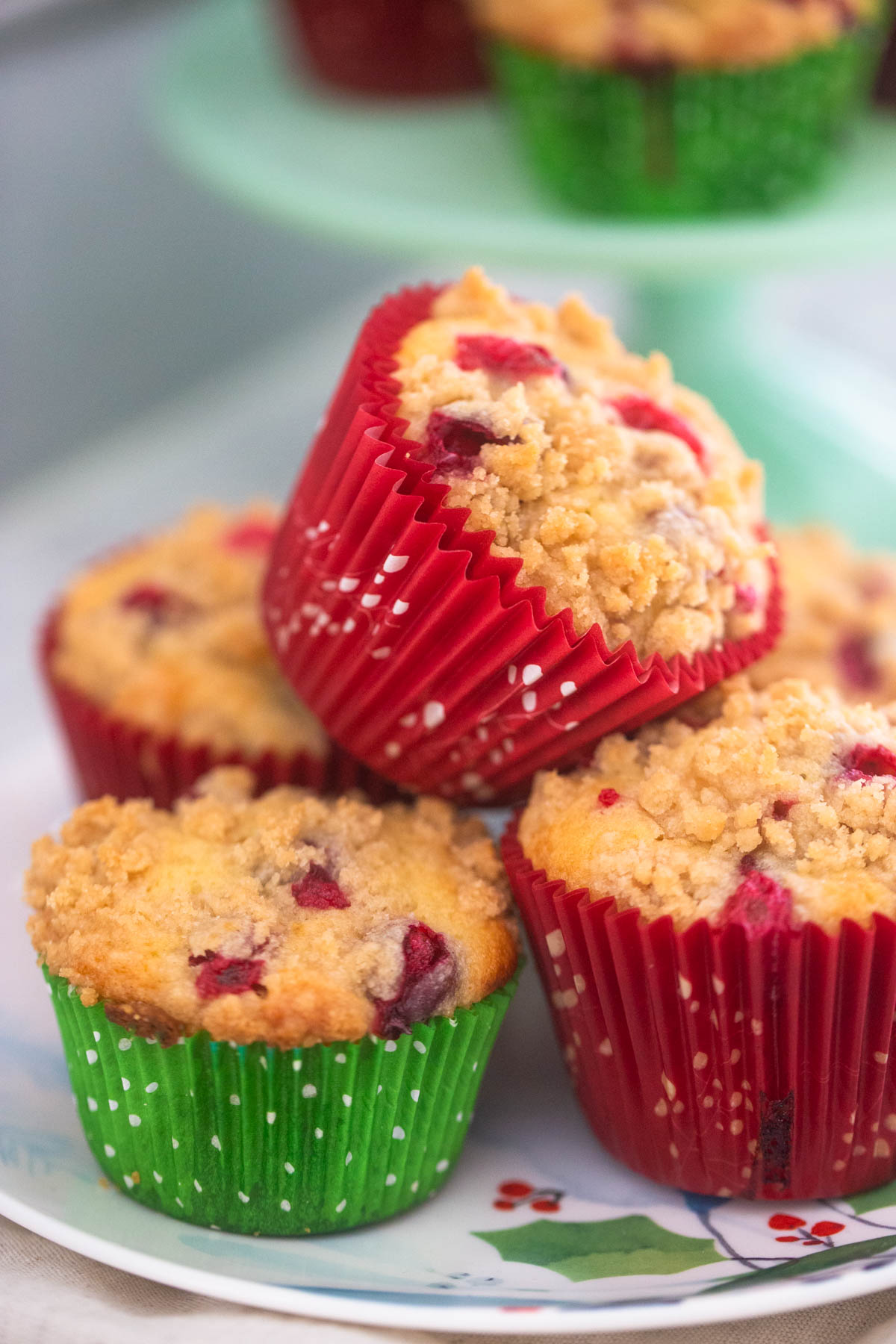 A holiday plate has cranberry orange muffins in red and green muffin liners.