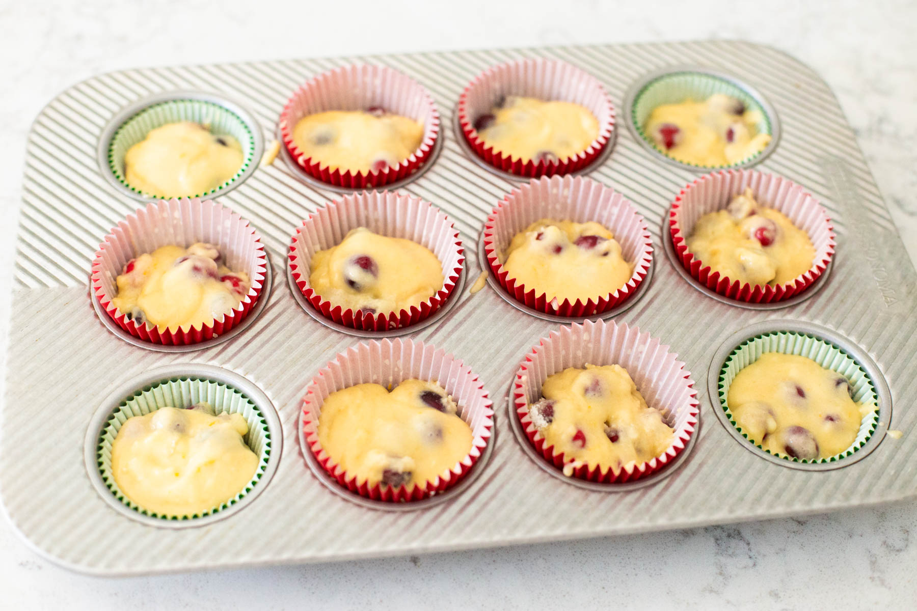 The muffins are in cupcake liners in a muffin tin.