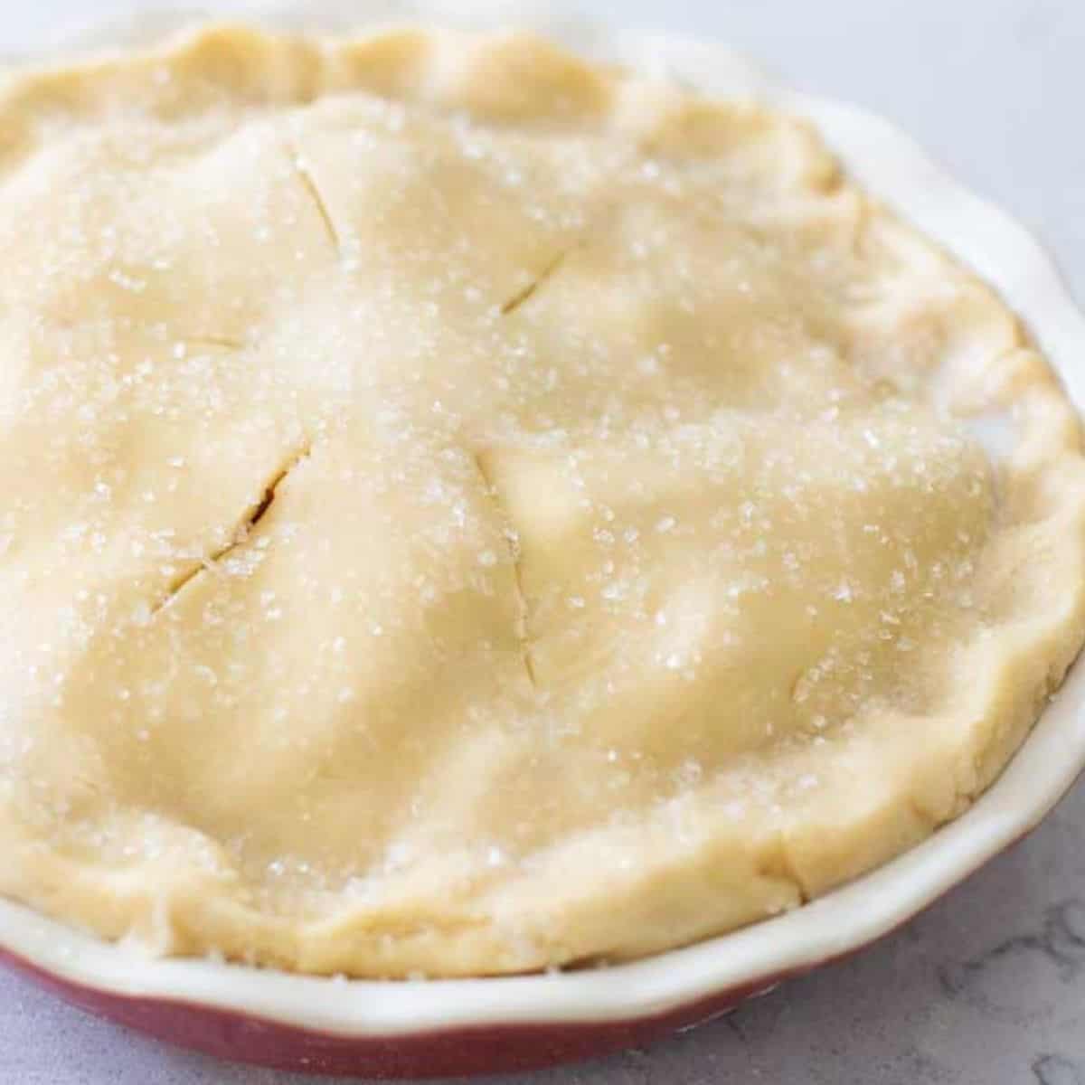 An apple pie dusted with sparkling sugar on top.