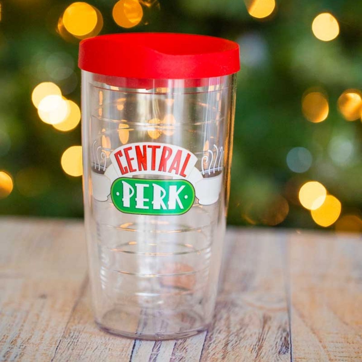 A Central Perk "Friends" tumbler in front of a Christmas tree.