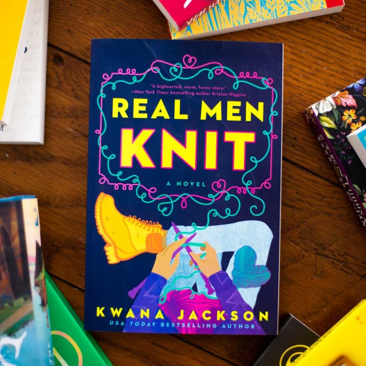 Cover of the book Real Men Knit by Kwana Jackson sits on a table.