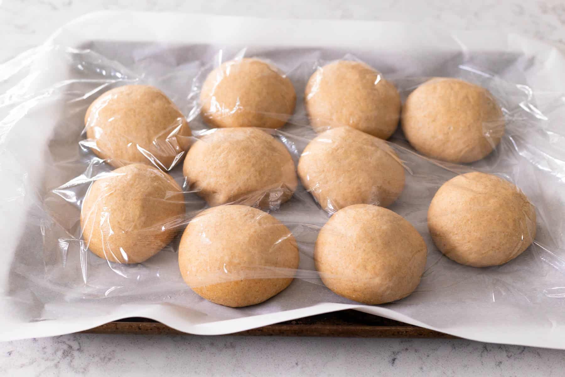 The buns are covered with plastic wrap and rising.