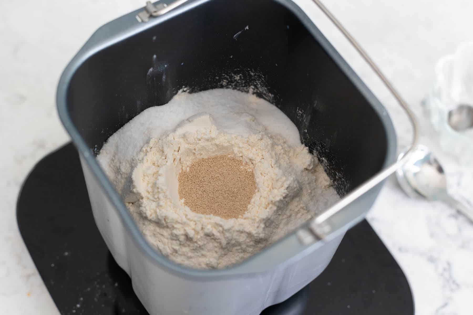 The flour is right on top of the liquid ingredients and there's a well in the center for the yeast.
