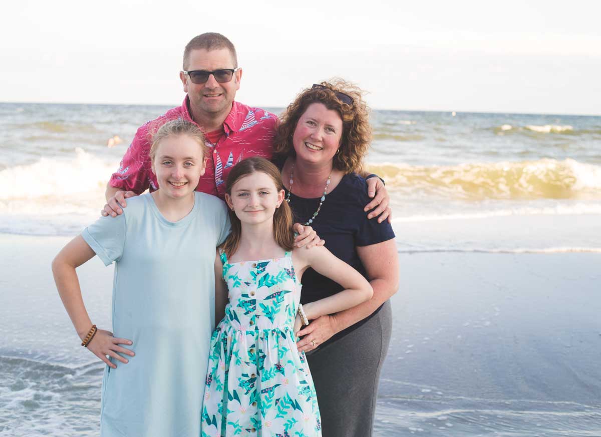Tiffany Dahle with her husband and two daughters on the beach.