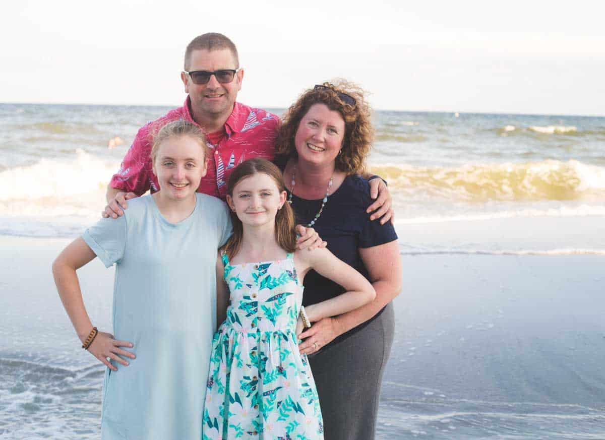 Tiffany Dahle with her husband and two daughters on the beach.