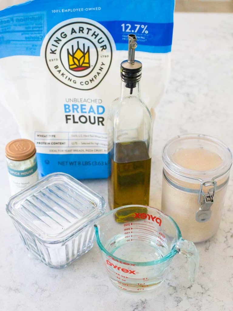 The ingredients to make homemade pizza dough in the bread machine are on the counter.