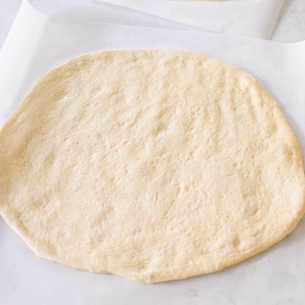 Pizza dough from the bread machine has been rolled out into a circle and is ready for toppings.