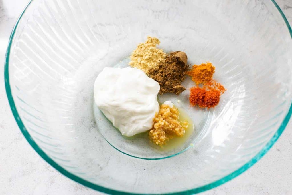 The tandoori chicken marinade ingredients in a mixing bowl before stirring together.