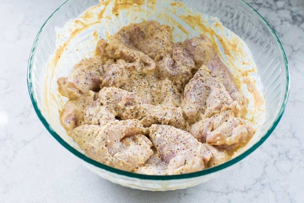 Chicken thighs coated in tandoori marinade before storing in fridge.