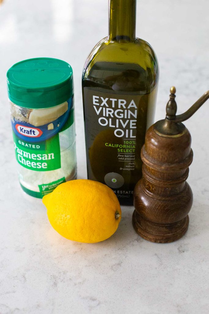 The ingredients for lemon parmesan vinaigrette sits on a counter.