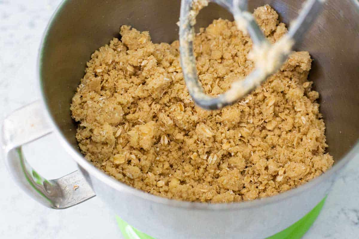 The finished crisp topping is in the bowl of the stand mixer and shows how it is clumping together.