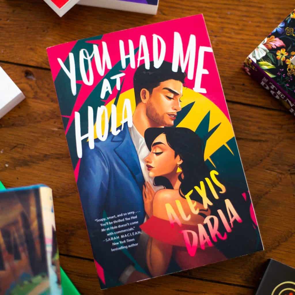 The book "You Had Me At Hola" sits on a table.