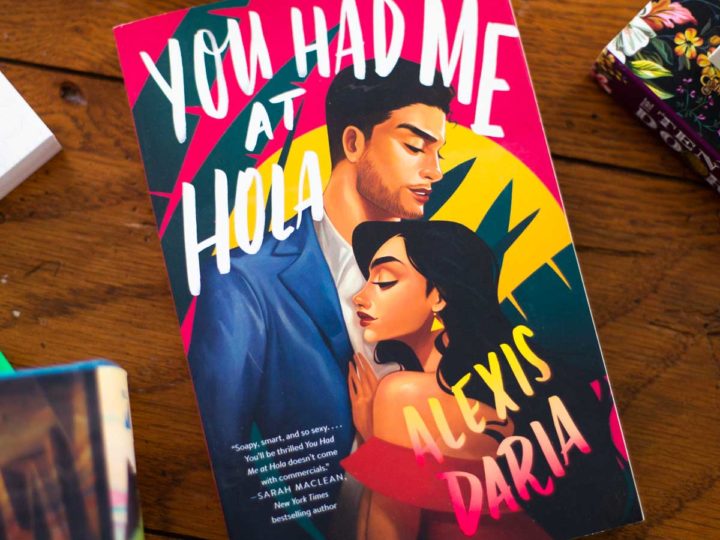 The book "You Had Me At Hola" sits on a table.