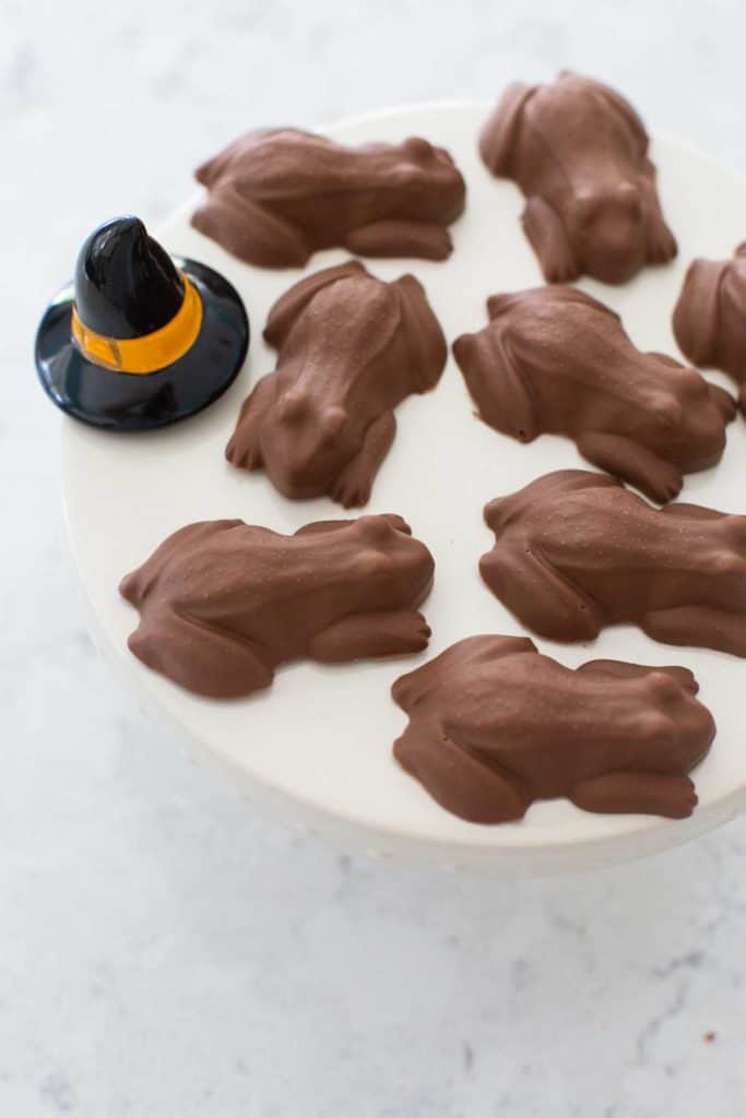 A platter of chocolate frogs sits next to a ceramic witch hat.