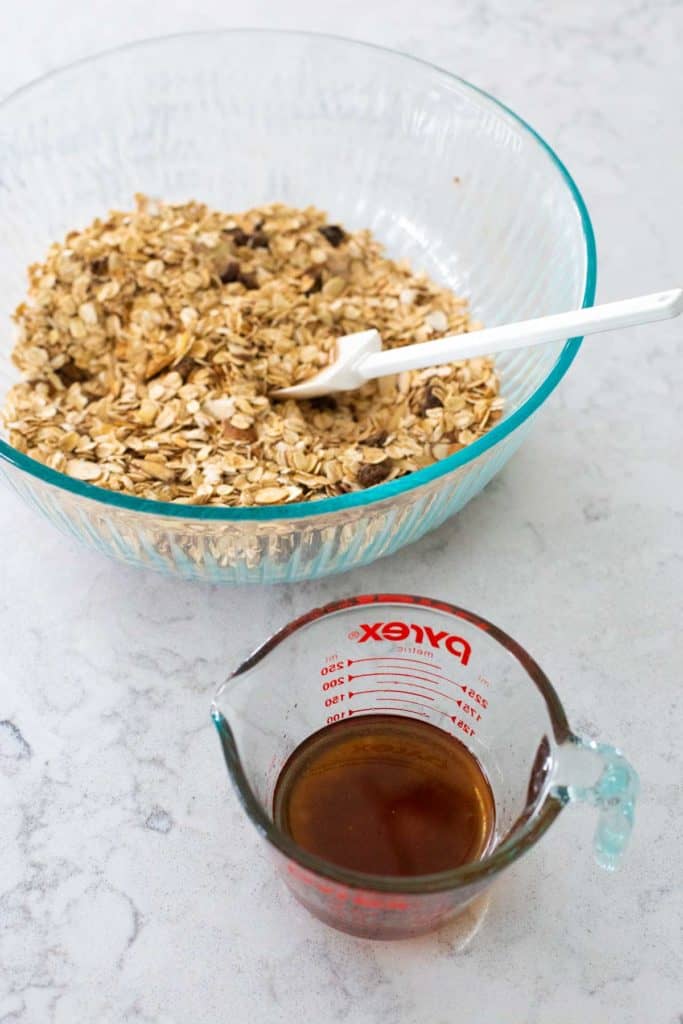 The maple syrup and honey are ready to be poured into the bowl of granola mix.