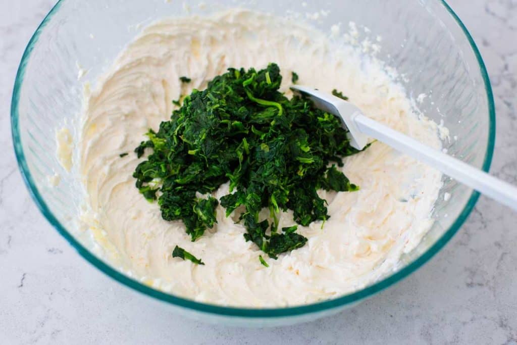 Thawed frozen spinach is ready to be mixed into the cream cheese.