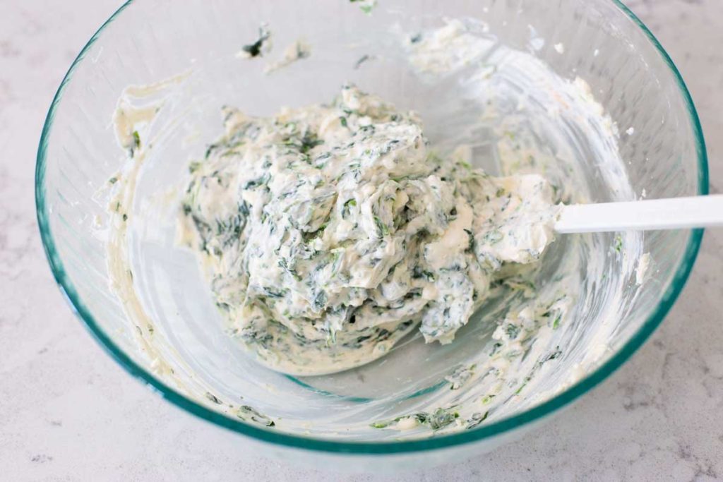 The frozen spinach has been drained and stirred into the cream cheese.