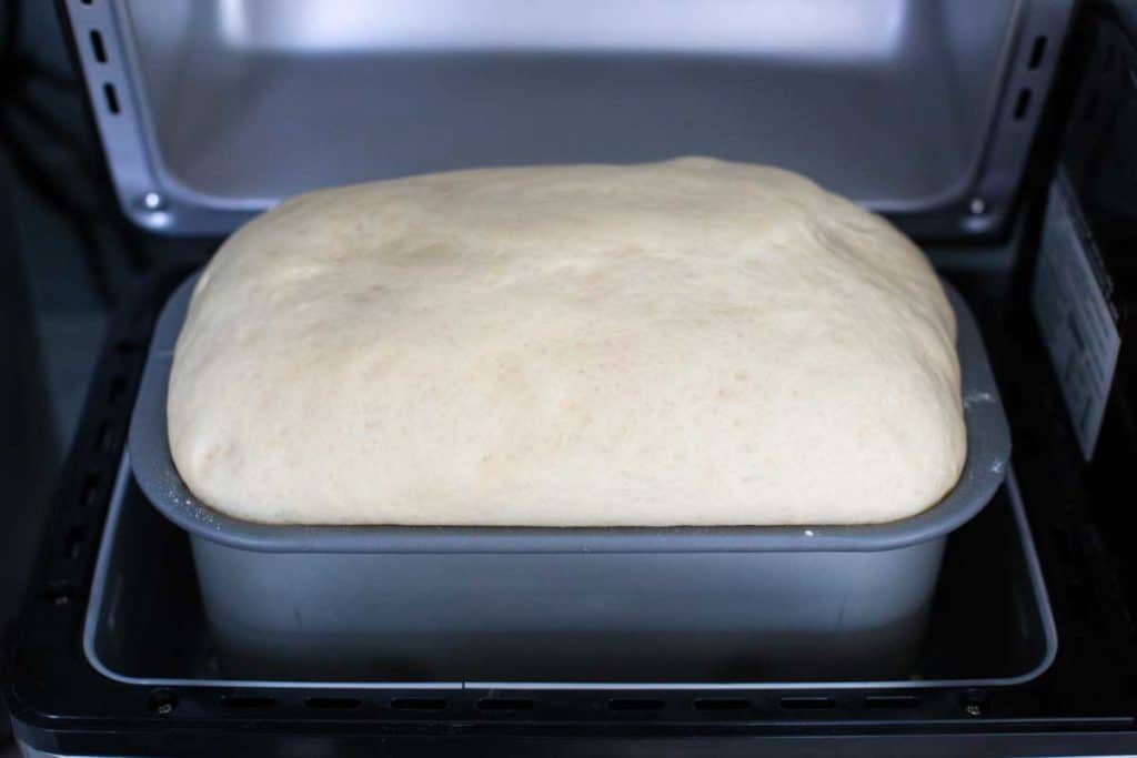 Bread has risen inside a bread machine.