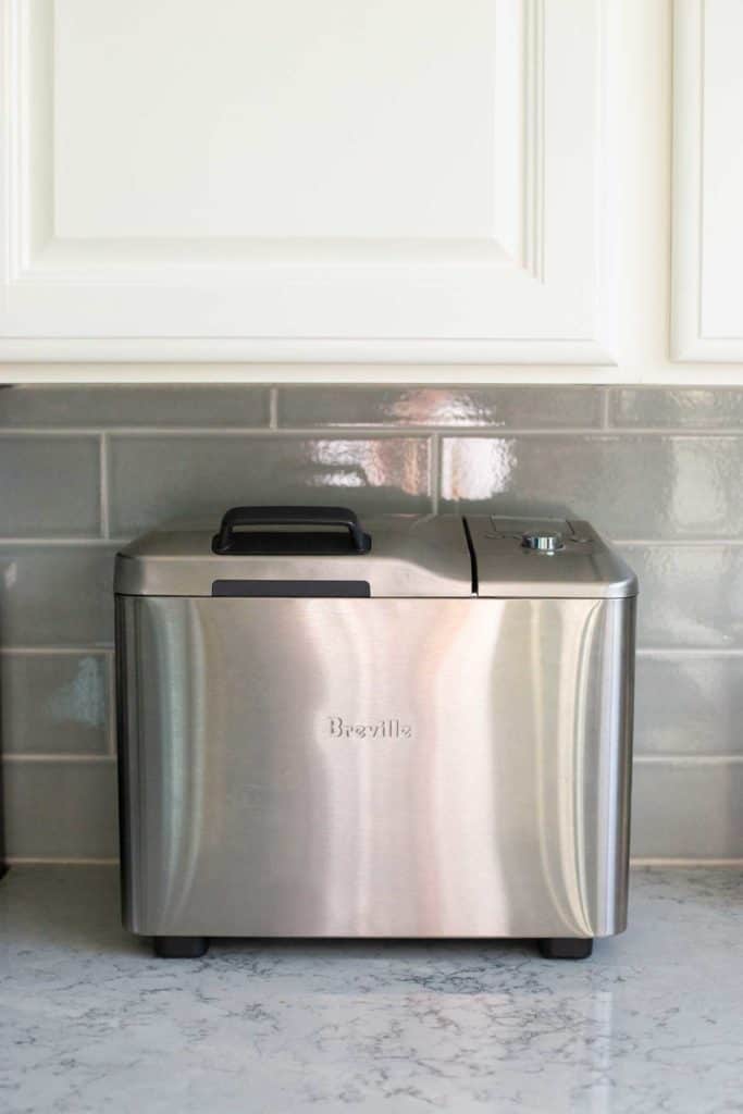 The Breville bread maker is shown underneath a kitchen cabinet to illustrate the height and size of the machine.