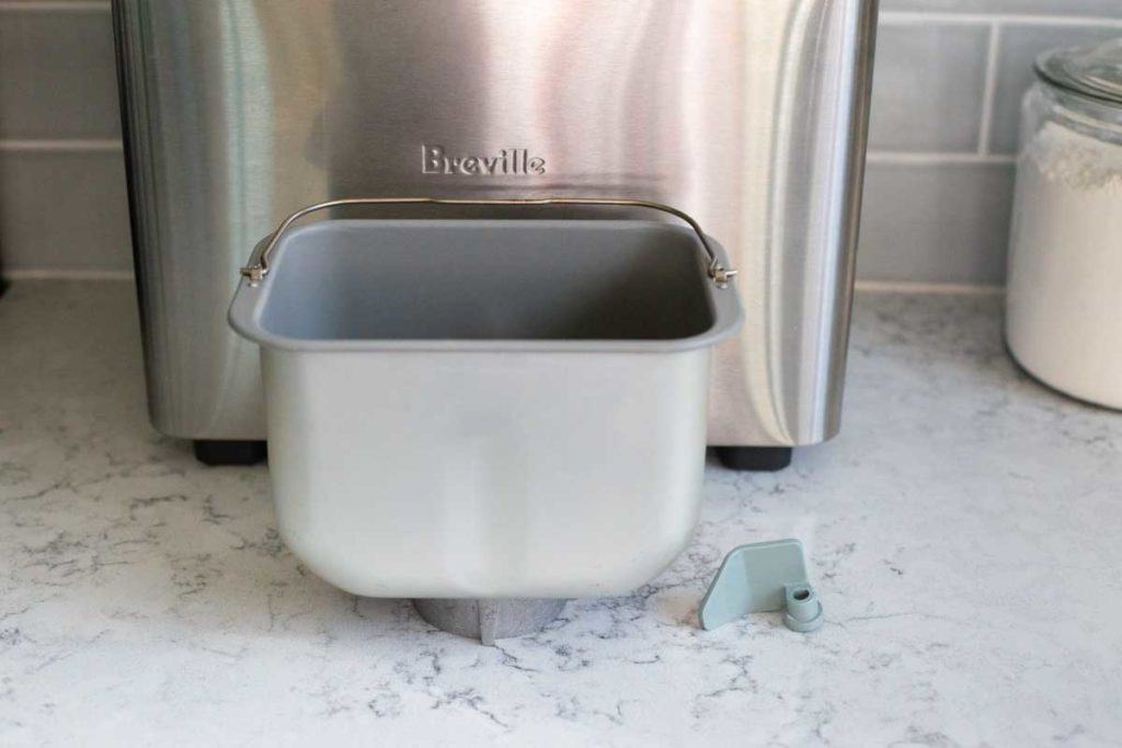 The Breville bread machine bread pan and paddle are displayed next to the machine.