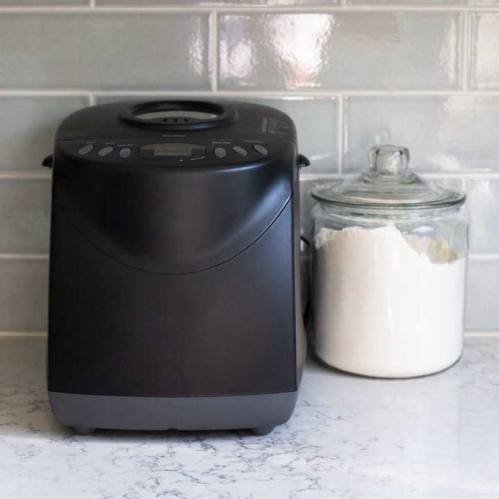 The Hamilton bread machine sits on a kitchen counter next to a jar of flour.