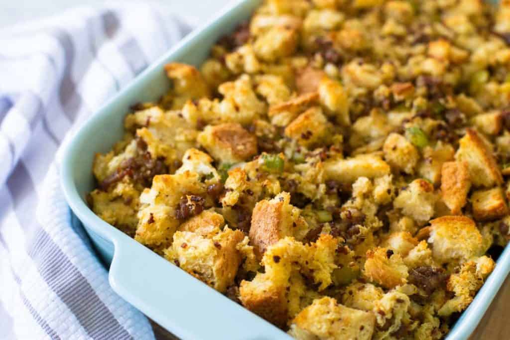 A blue baking dish filled with savory sausage stuffing.