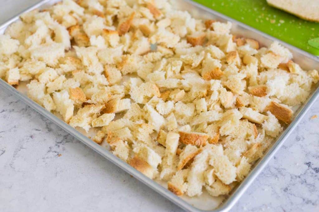 The bread has been torn into pieces and toasted on a baking sheet.