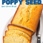 The baked almond poppy seed bread is ready to be served for breakfast and has a knife on the side of the platter.