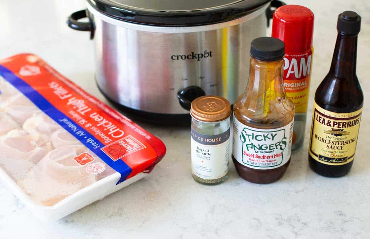 Ingredients for the bbq crockpot chicken are next to the Crockpot.