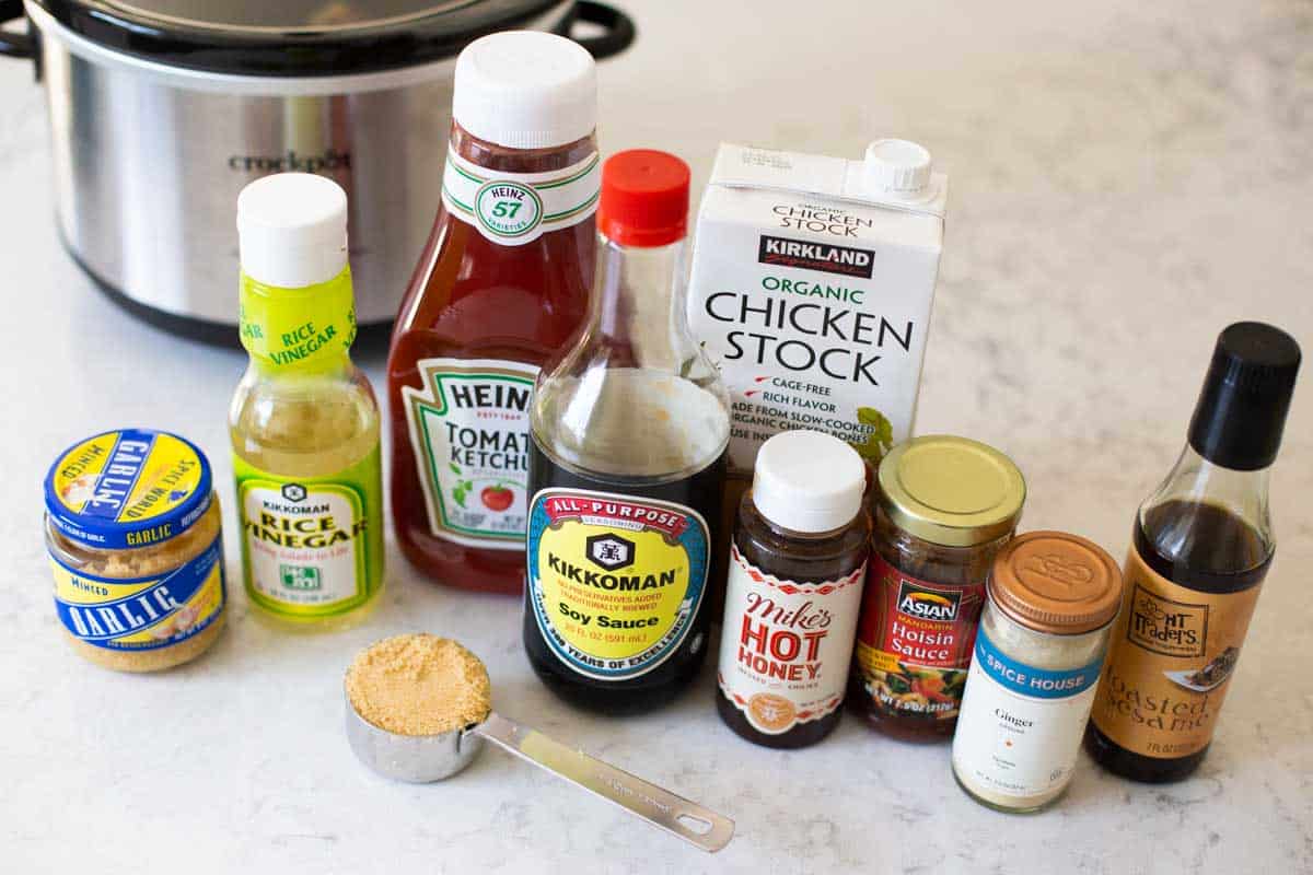 The ingredients for the bourbon chicken recipe are sitting in front of a slowcooker.