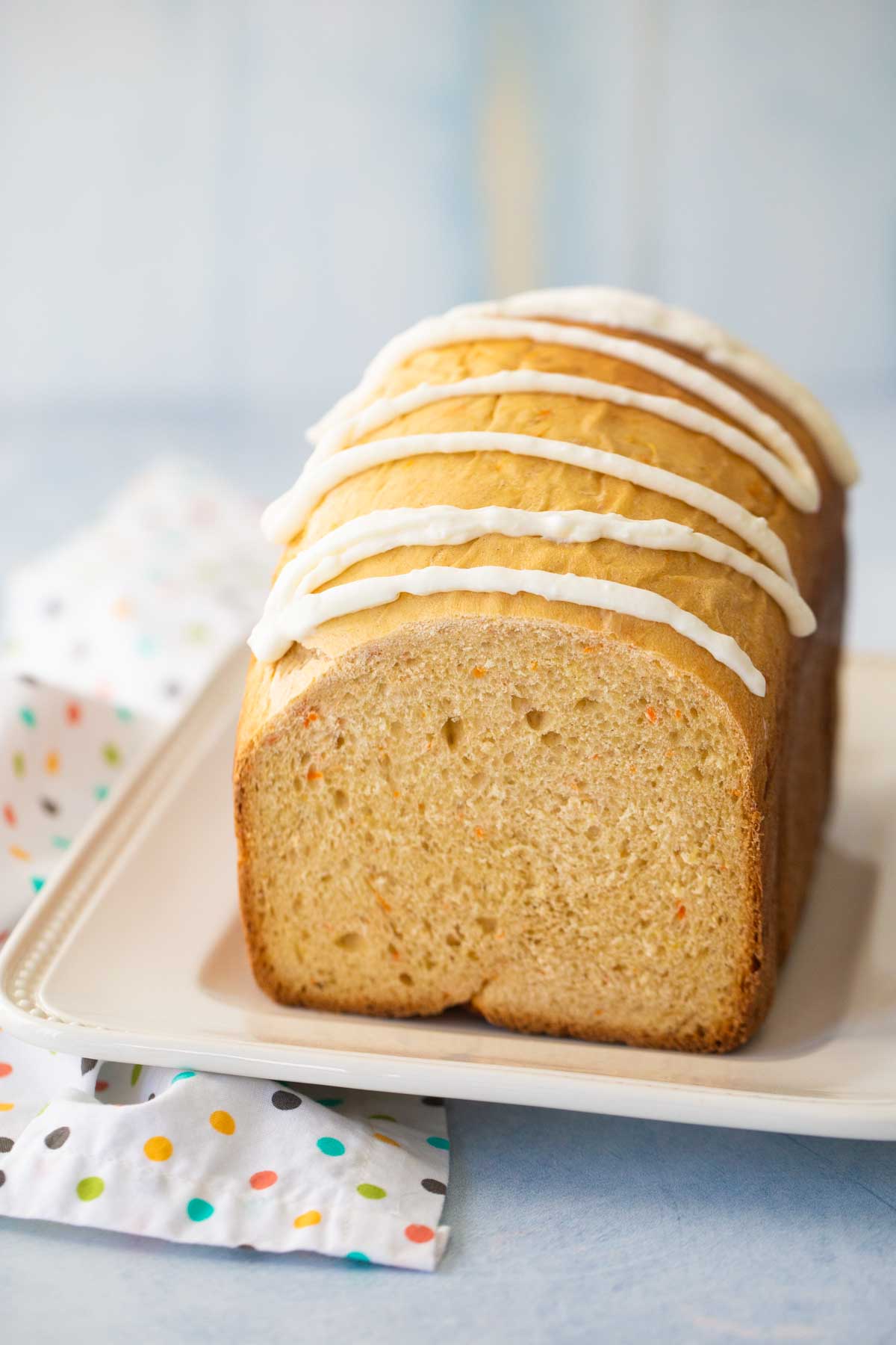 The finished bread is served on a white platter with a cute napkin draped on the side.
